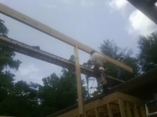 Carpenter setting a ridge beam over a new addition frame — Ice Dam Removal by Roofing Brothers in Chariton