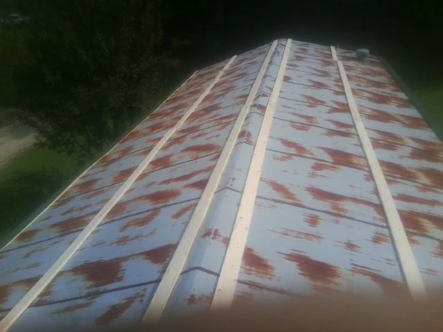 Rusted metal roof panels with new wood purlins before replacement — Storm Damage Roof Repair in Chariton by Roofing Brothers