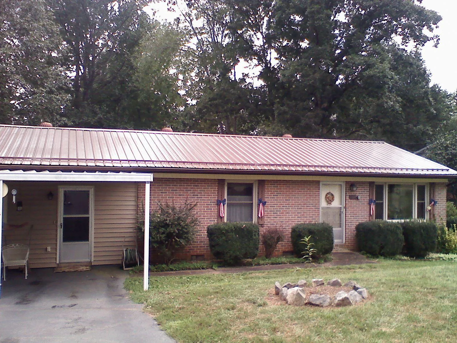 Bronze metal roof and carport on a brick ranch home — Roof Repair work by our crew in Chariton
